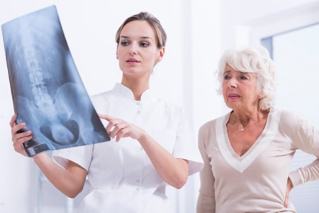 a doctor shows a patient an x-ray of the spine